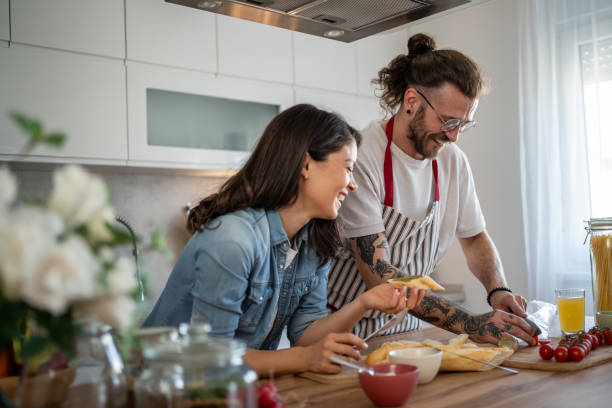 istock Young couple having fun cooking together in a modern kitchen 2203379628