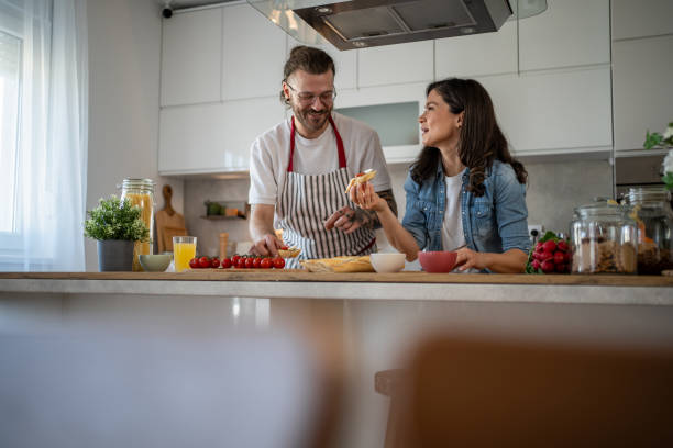 istock Happy couple preparing food and having fun in the kitchen 2203379656