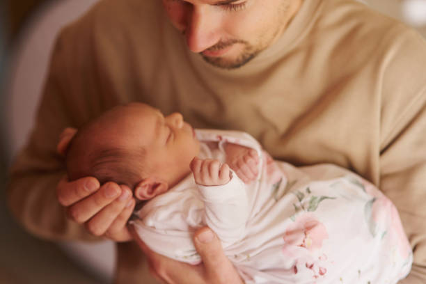 istock Dad, support and holding sleeping baby in home for growth, development and bond to connect with infant. Above, love and father for protection in childhood, newborn nap and child with dream in embrace 2203380067