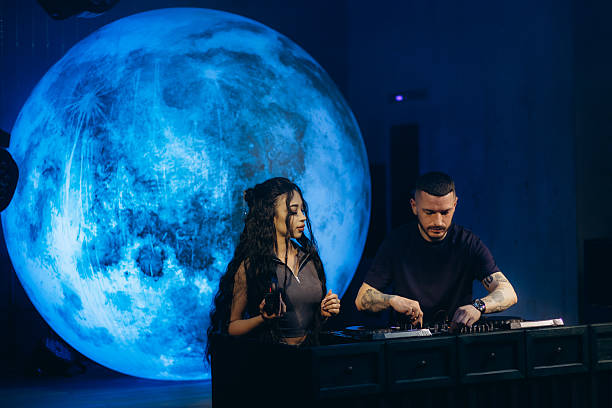 istock Two DJs Performing Live in Front of Blue Lunar Installation 2203380442