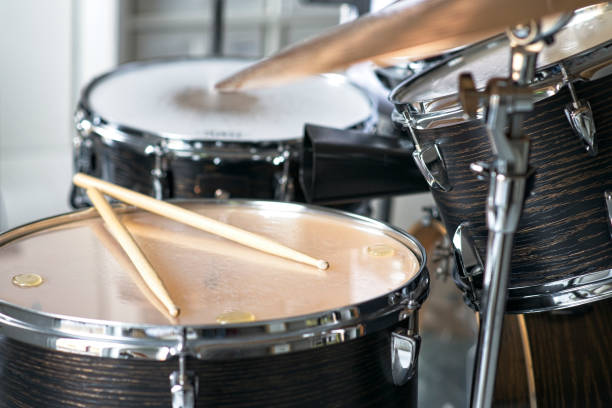 istock Drum kit, pair of drumsticks are lying on a floor tom during drum practice 2203380824