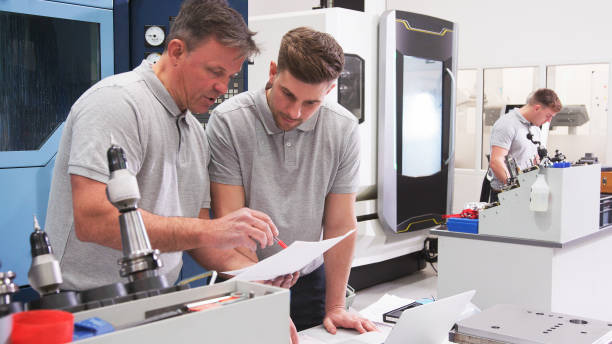 istock Male Engineer And Apprentice Discussing Plans For Job Whilst Looking At Laptop 2203384389