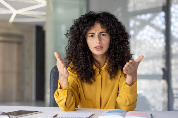 istock An expressive young woman gestures emphatically during a serious conversation on a video call, filmed from the POV perspective in a business setting. 2203386355