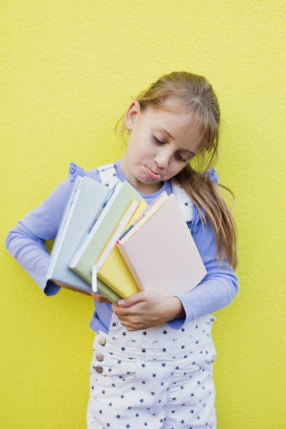 Little girl love books while standing at home and smiling