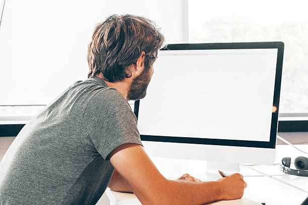 istock Bearded young businessman working at modern office 2203387483