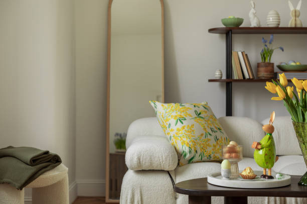 istock Bright living room with an Easter setup featuring yellow tulips in a white vase, soft textured pillows, and delicate decorations, creating a warm and festive ambiance. 2203387969