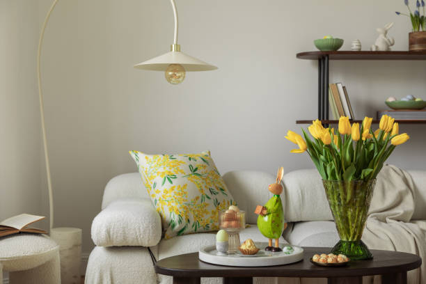 istock Spring-inspired Easter display with fresh yellow tulips, ceramic bunny figurines, and pastel eggs in a stylish home setting. 2203388718
