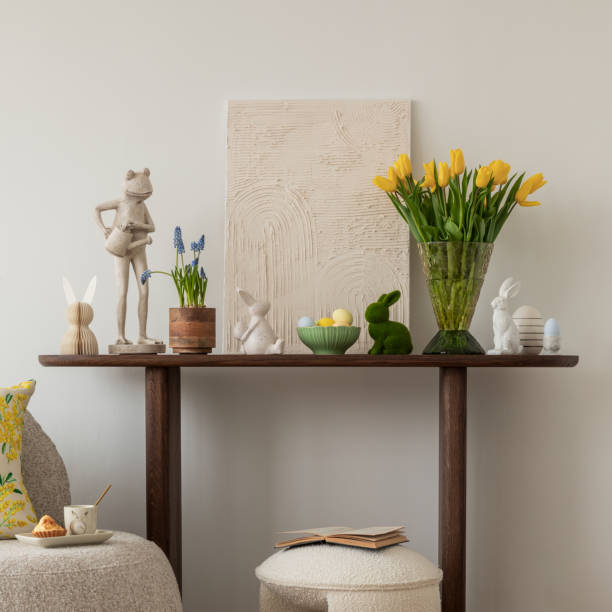 istock Easter table setting in a cozy living space with fresh yellow tulips, a white ceramic vase, and a decorative chicken figurine. A soft color palette and pastel accents create a festive atmosphere. 2203388924