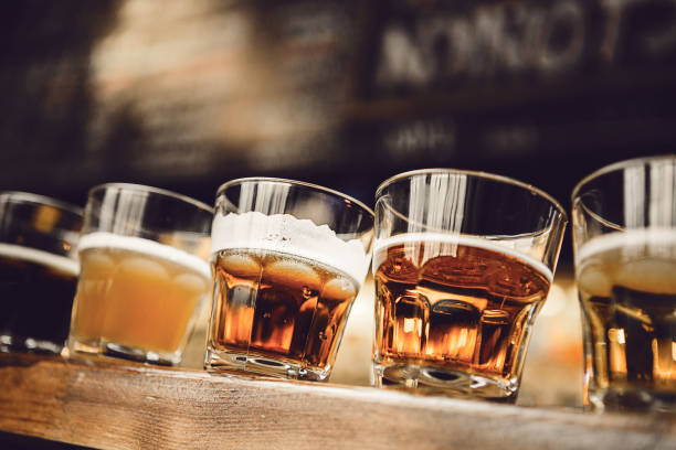 istock Small Beer Tasting Sets Arranged Neatly on Wooden Shelf in Bar, Highlighting Various Craft Brews and Flavors 2203388983