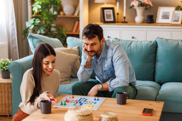 istock Couple having fun playing ludo board game at home 2203394184