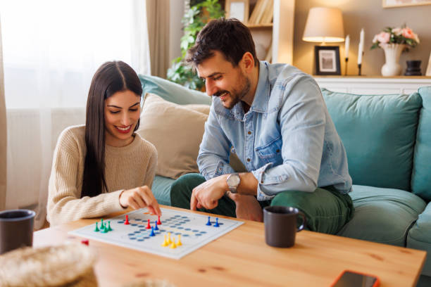 istock Multi-ethnic couple playing ludo board game at home 2203394219