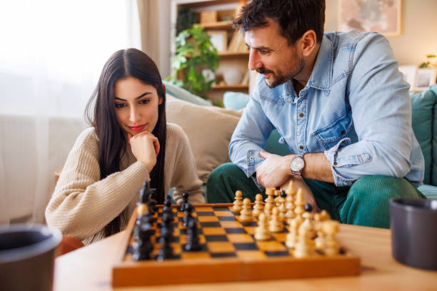 istock Beautiful young multi-ethnic couple playing chess at home 2203394778