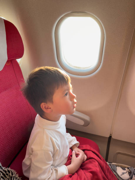 istock Thoughtful Boy Sitting on Plane by Window 2203394931