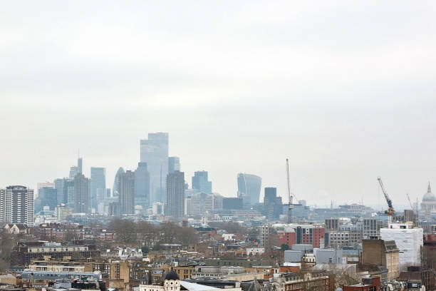 London, United Kingdom, January 17, 2025: Urban skyline featuring a blend of modern skyscrapers and construction cranes against a cloudy backdrop. the scene dynamic growth and architectural diversity of a bustling city environment.