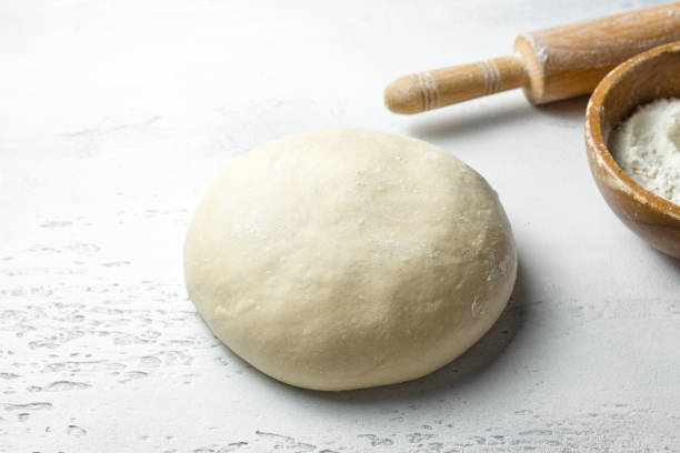 istock Freshly kneaded dough with rolling pin for homemade baking preparation on a light gray background 2203395831