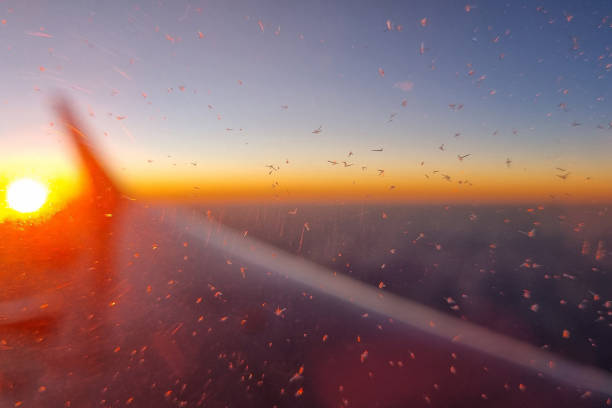 A breathtaking view from an airplane window capturing the vibrant sunset over the horizon. sunlight creates a spectacular gradient of warm colors across the sky, with the aircraft wing silhouetted against the radiant backdrop.