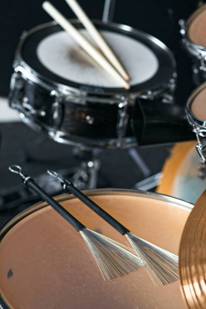 istock Pair of jazz drum brushes lying on a floor tom during music session 2203397147