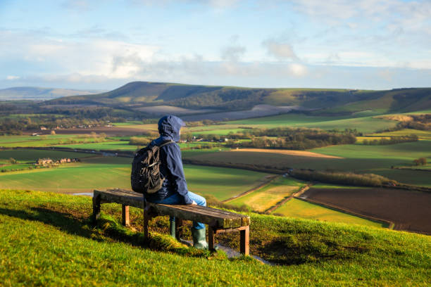 istock Hiker sitting on bench looking at view on South Downs in southeast England 2203399193