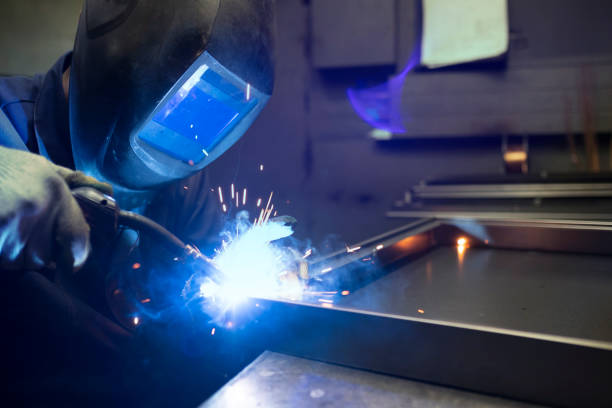 istock Industrial worker welding metal at factory workshop with flying sparks 2203400253