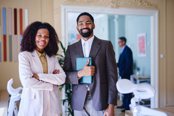 istock Smiling business people standing in modern office 2203401271