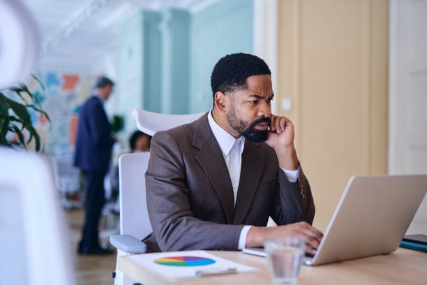 Focused businessman working on laptop in modern office