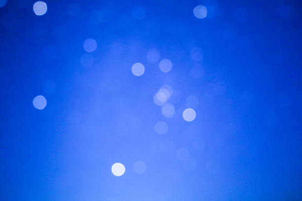The photograph shows a blue background with blurred white circles. The circles create a bokeh effect, scattered across the background. The background is uniform, the color is saturated.