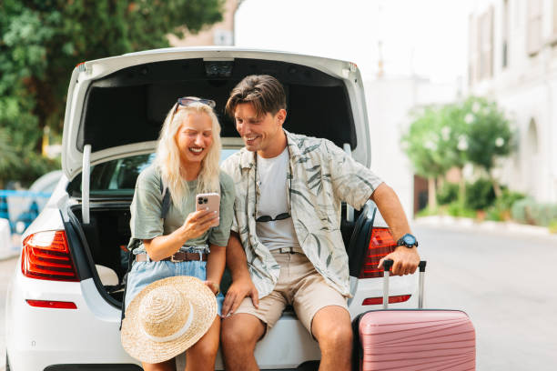 istock Young couple sitting in an open car trunk 2203402640