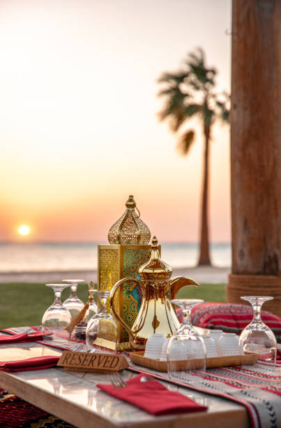 istock Traditional Arabic seating sofa and festive Iftar table with coffee and dates for ramadan fast breaking celebration in outdoor beach side in Abu Dhabi 2203402942