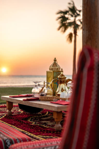 Traditional Arabic seating sofa and festive Iftar table with coffee and dates for ramadan fast breaking celebration in outdoor beach side in Abu Dhabi