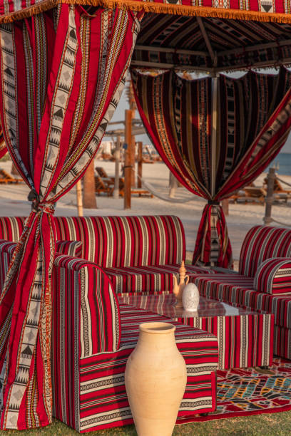 Traditional Arabic seating sofa and festive Iftar table with coffee and dates for ramadan fast breaking celebration in outdoor beach side in Abu Dhabi