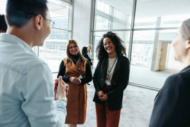 istock Colleagues networking at a corporate event in a modern office building 2203404003