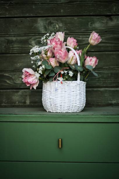 istock Charming white wicker basket filled with pink tulips and small white flowers 2203404658