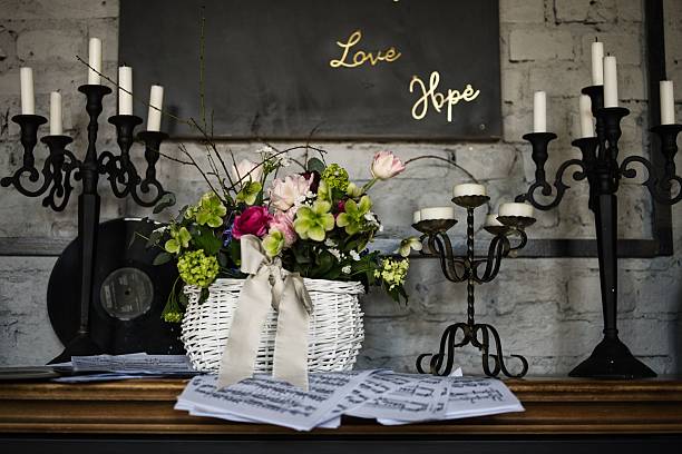 istock Rustic interior with a floral arrangement in a white basket, surrounded by candles and sheet music 2203404665