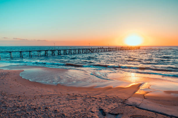 istock People silhouettes on Port Noarlunga jetty at sunset 2203405880