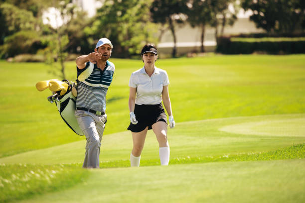 istock Man carrying golf bag and talking to female golfer on the golf course 2203406484