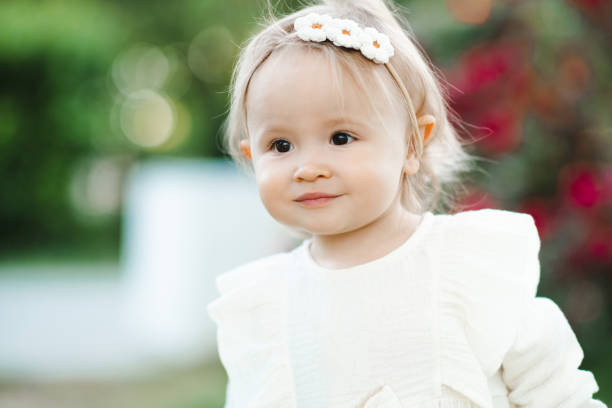 istock Kid girl with flowers in park 2203407159