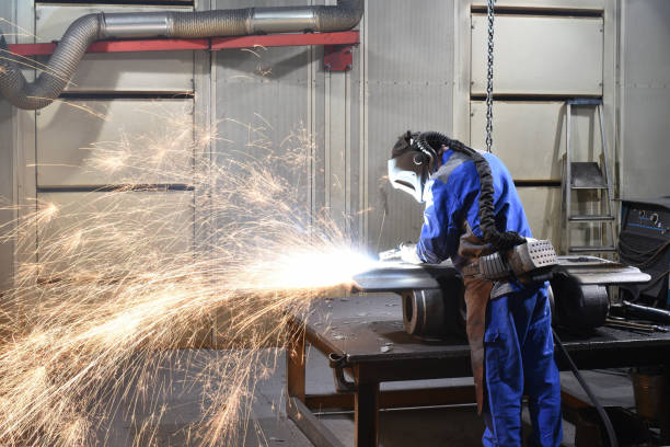 istock Workers in protective equipment in a foundry work on a casting with a grinding machine at the workplace 2203414893