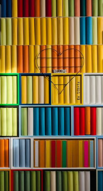 istock Library, colorful generic books spines with a heart shape hanging at it, Morning sun rays on the books 2203415690