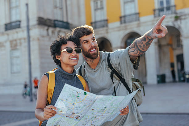 istock Tourists looking map and pointing in city center 2203417929