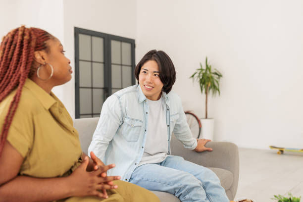 istock Multicultural Couple Enjoying a Conversation on the Sofa 2203418776