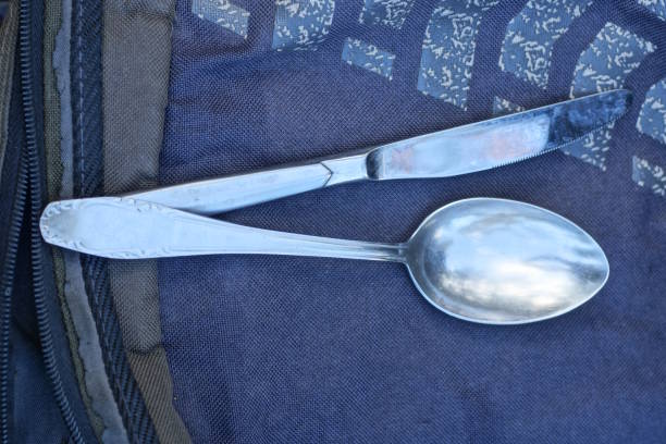istock old grey metal spoon and knife lie on black table 2203418807