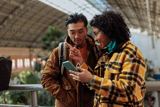 istock Tourists using smart phone app for navigating in train station, madrid 2203420054