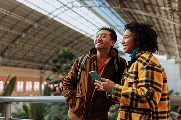 istock Tourists consulting smart phone inside railway station in madrid 2203420113