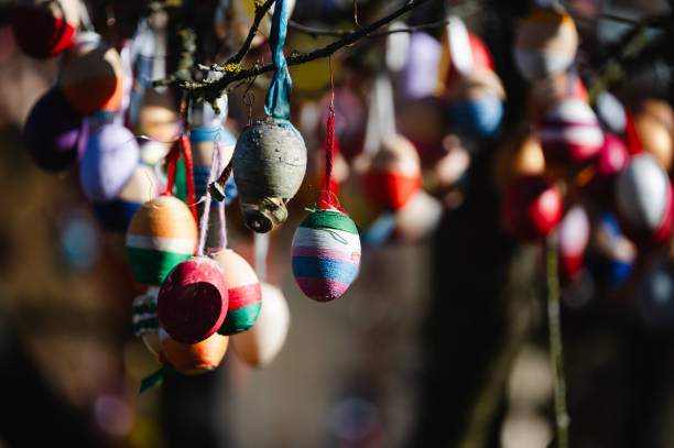 istock Close-up of colorful Easter eggs hanging on a tree branch 2203422423