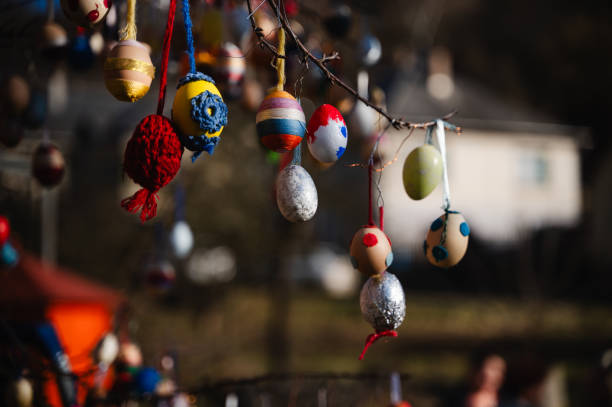 istock Close-up of colorful Easter eggs hanging on a tree branch 2203422489