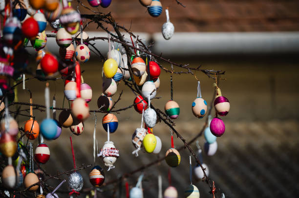 istock Close-up of colorful Easter eggs hanging on a tree branch 2203422496