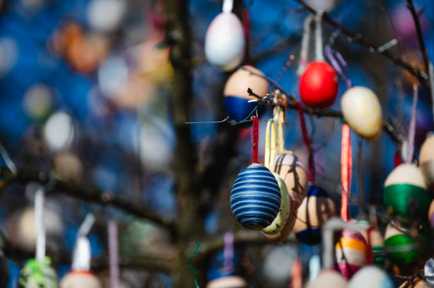 istock Close-up of colorful Easter eggs hanging on a tree branch 2203422517