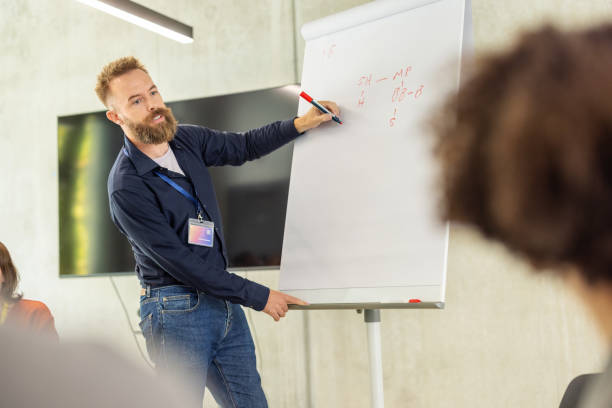 istock Businessman presenting with flipchart to multiracial audience at convention hall 2203423699