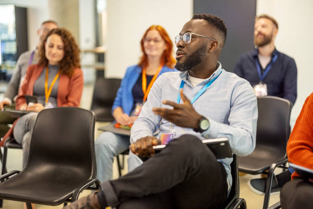 istock African businessman interacting with presenter during business seminar 2203423717