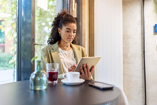 istock Businesswoman sitting at cafeteria using digital tablet 2203423863